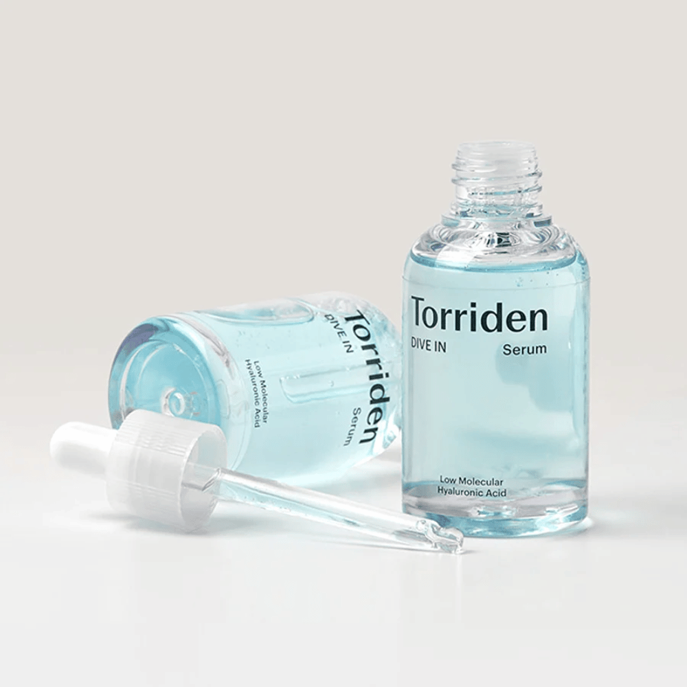 Una botella de Torridens DIVE-IN Low Molecule Hyaluronic Acid Serum 50ml junto a una botella de agua, destacando el suero de ácido hialurónico e hidratación.