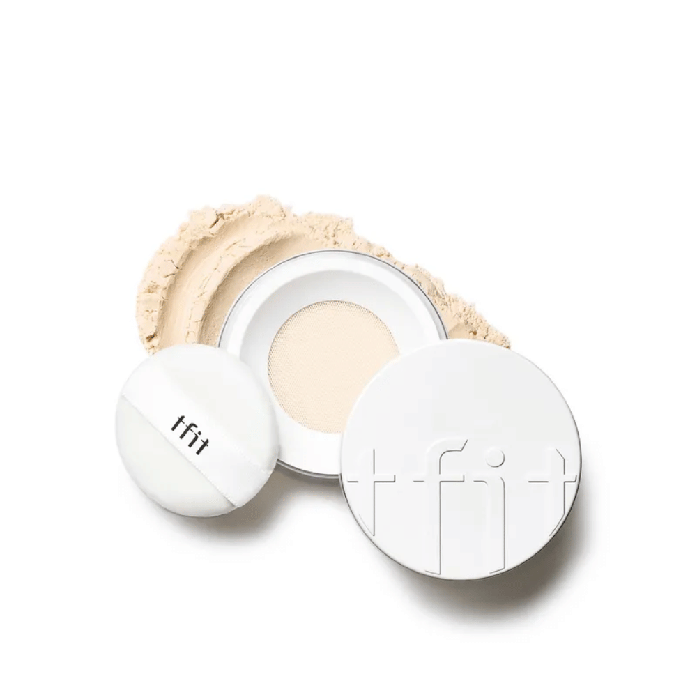 Dosa abierta con TFIT Translucent Set Finishing Powder en el tono Skin Beige, con puff incluido y setting powder esparcido alrededor.