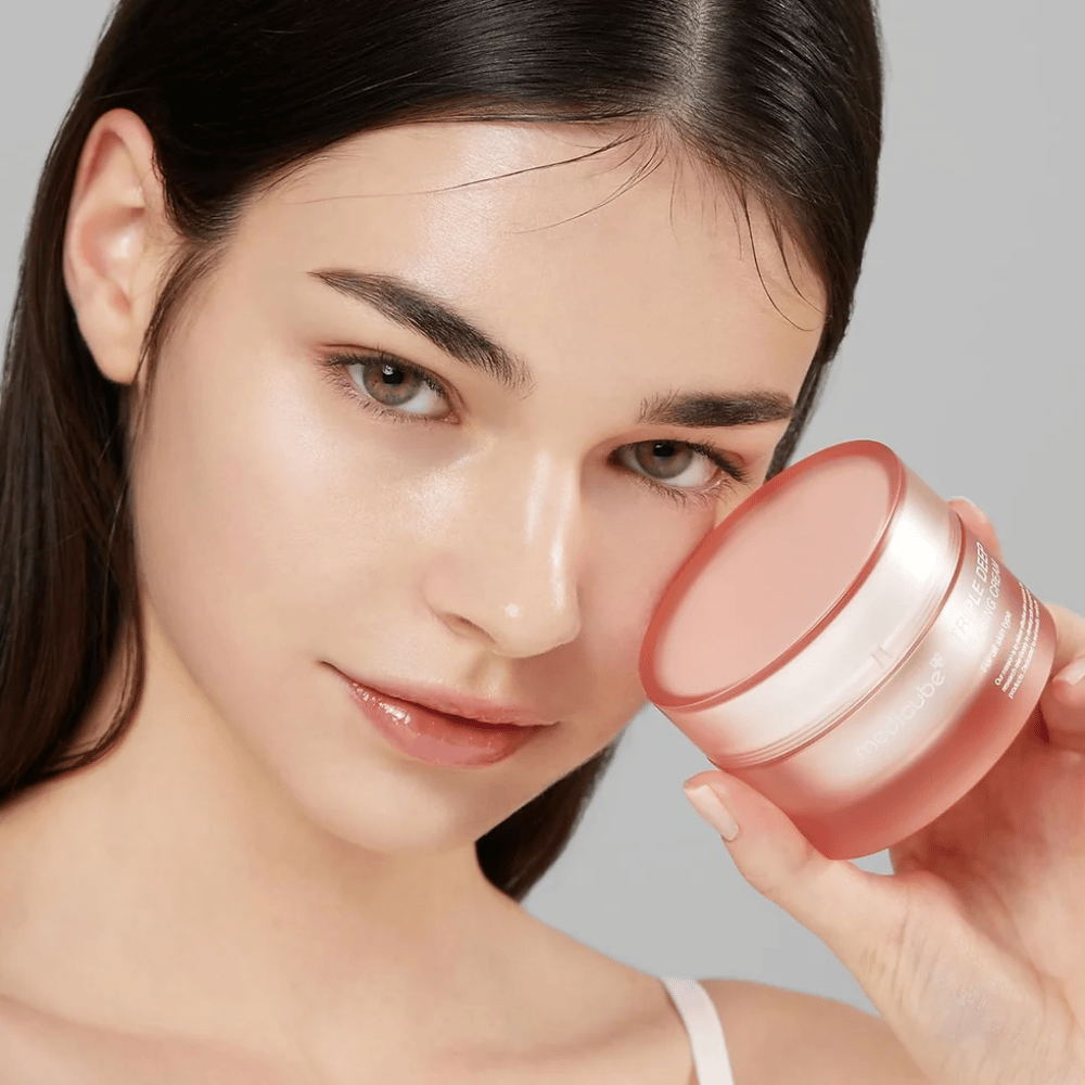 La imagen muestra a una mujer sosteniendo un frasco de Triple Collagen Cream. La crema está diseñada para mejorar la elasticidad y la hidratación de la piel. La piel de la mujer se ve suave y bien cuidada.




