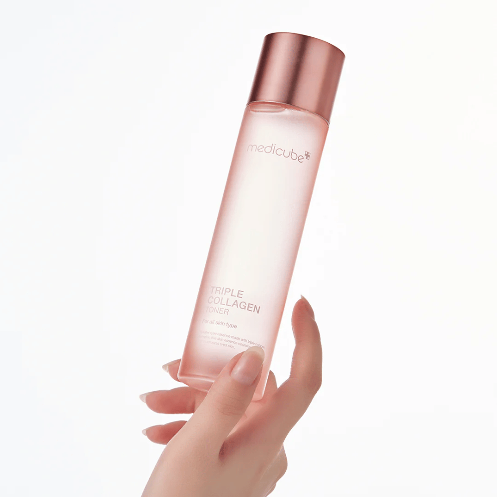 Mano sosteniendo una botella rosa de Medicube Triple Collagen Toner 4.0, un tónico hidratante y reafirmante para todo tipo de piel.