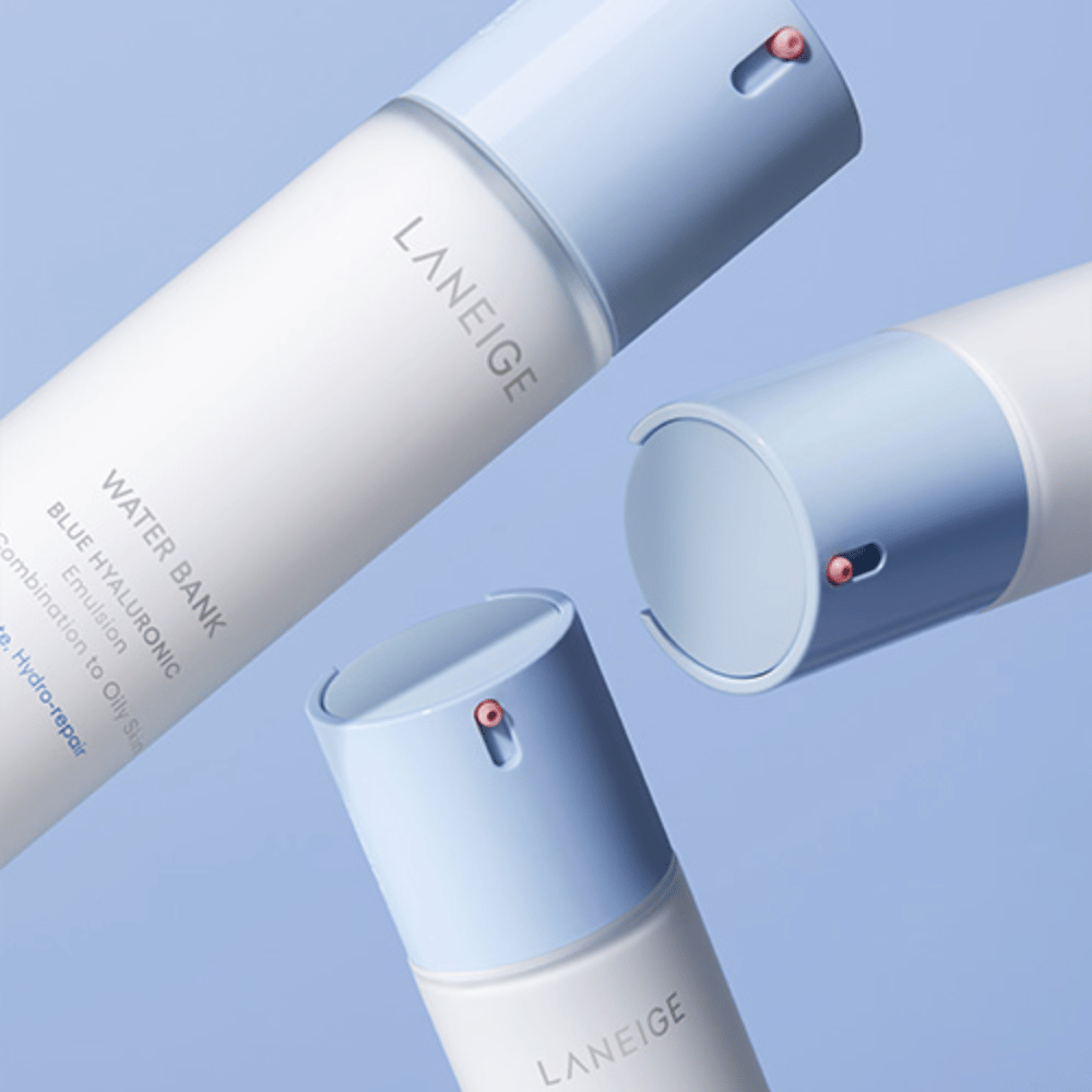 Tres botellas de LANEIGE Water Bank Blue Hyaluronic Emulsion con cabezales de bomba azul claro sobre un fondo azul, mostradas desde diferentes ángulos.
