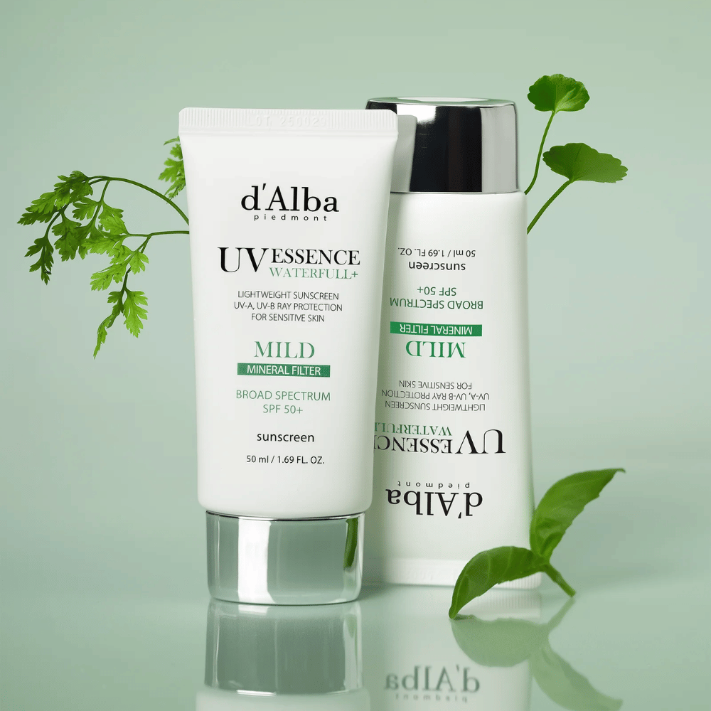 d’Alba Waterfull Mild Sun Cream SPF 50+ fotografiada con hojas verdes. Crema solar suave a base de minerales con protección de amplio espectro y fórmula hidratante para piel sensible.