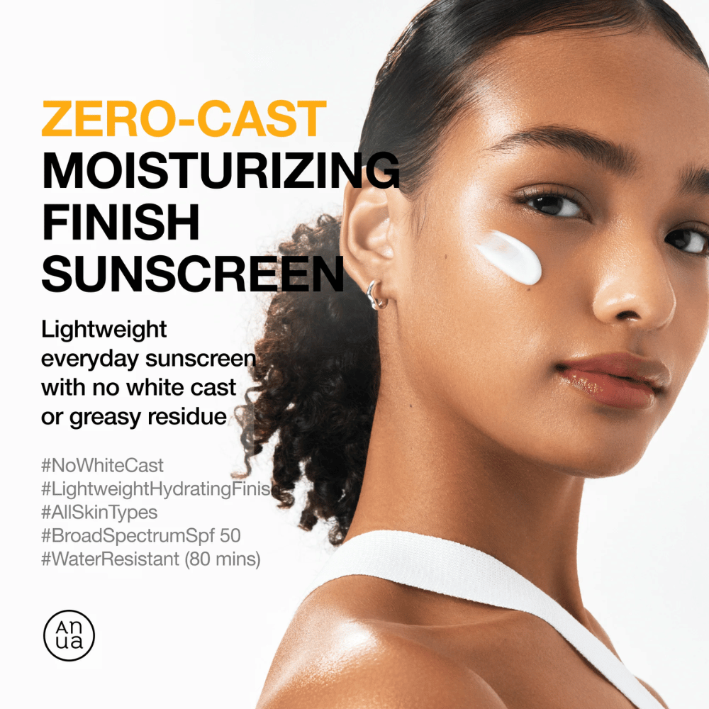 Mujer con crema solar en la mejilla muestra ANUA Zero-Cast Moisturizing Finish Sunscreen – una crema solar ligera e hidratante con SPF 50 que no deja una capa blanca.