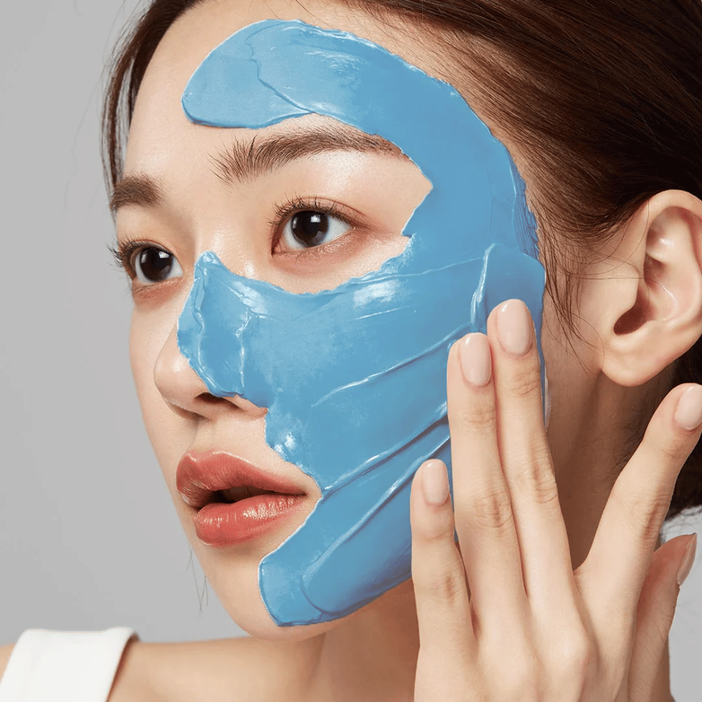 Modelo con mascarilla facial azul de Medicube, cubre la zona T para el cuidado de poros.