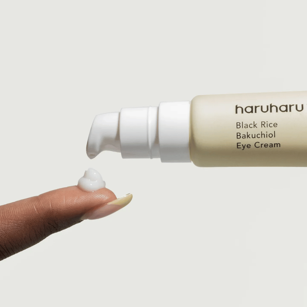 HaruHaru Wonder Black Rice Bakuchiol Eye Cream – primer plano de una bomba que dispensa crema en la punta del dedo, mostrando la consistencia para hidratación y anti-envejecimiento.