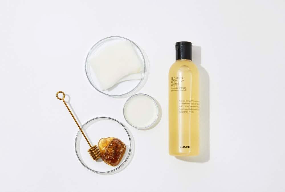 Una botella COSRX Full Fit Propolis Synergy Toner 150ml con efectos antiinflamatorios y antibacterianos, colocada sobre una superficie blanca.