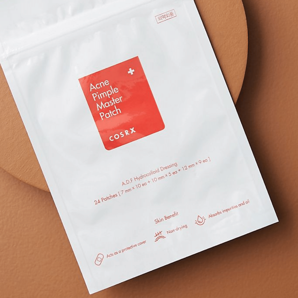 Un paquete COSRX Acne Pimple Master Patch (1pack x 24 parches) sobre un fondo marrón, con tecnología hidrocoloide para tratar el acné y las espinillas.