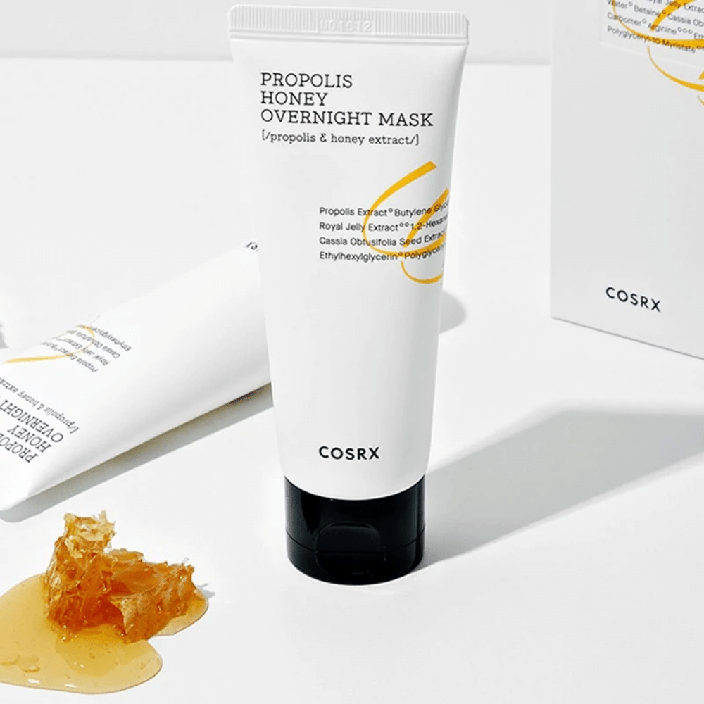 Una caja Full Fit Propolis Honey Overnight Mask 60ml de COSRX con una botella de miel al lado, con extracto de propóleo.