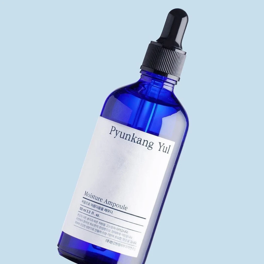 Una botella azul sobre fondo azul con Pyunkang Yul's Moisture Ampoule suero de 100ml.