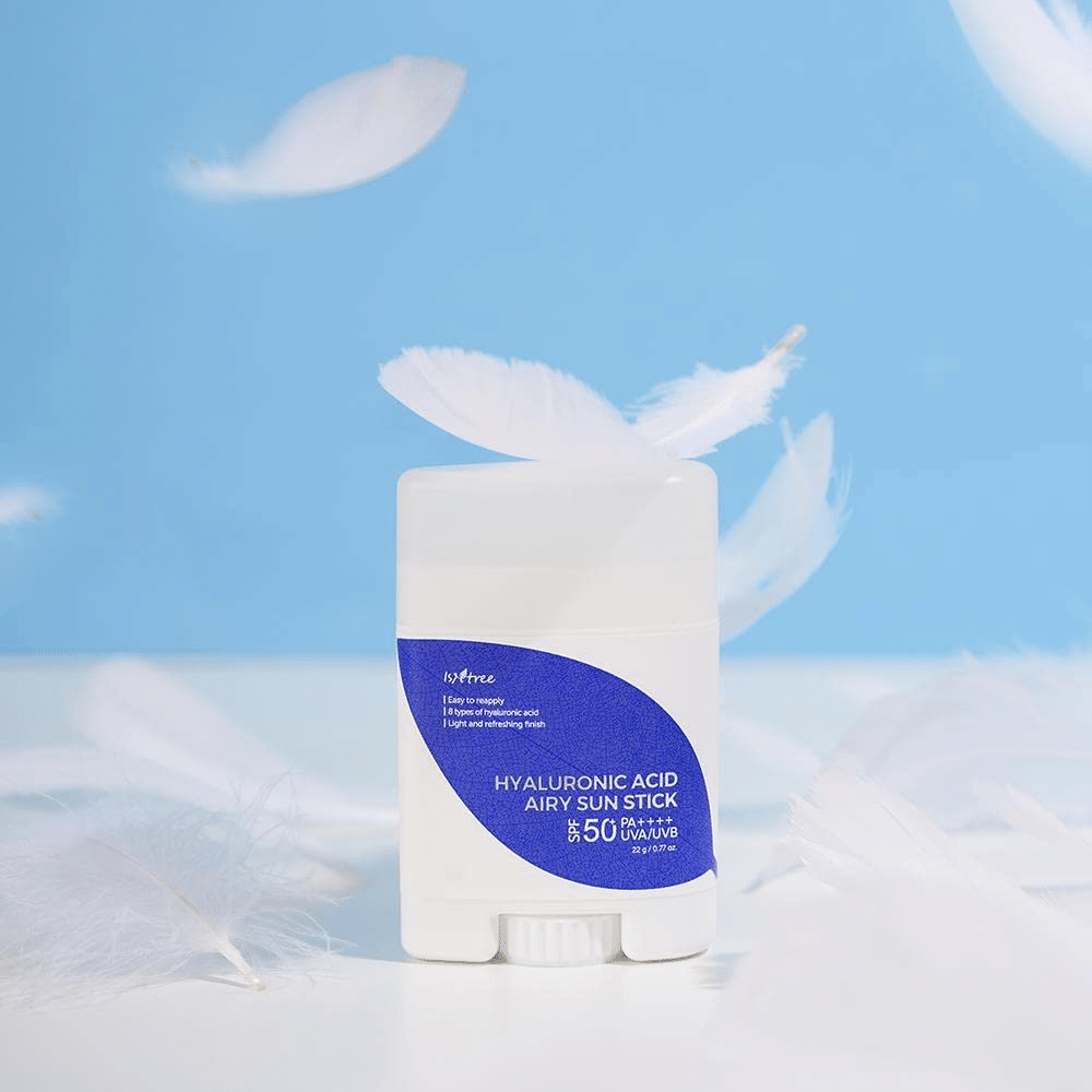 Un Isntree Hyaluronic Acid Airy Sun Stick con SPF 50+ y ácido hialurónico, adornado con plumas blancas.